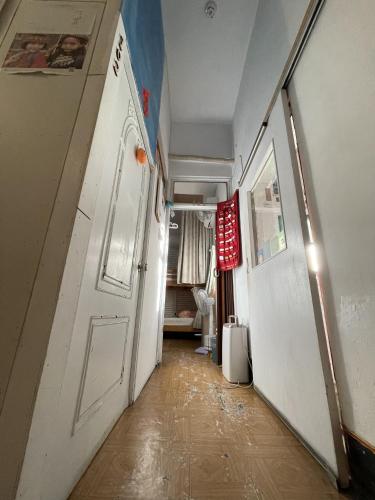 an empty hallway with a white door and a room at On My Way Dulan in Donghe