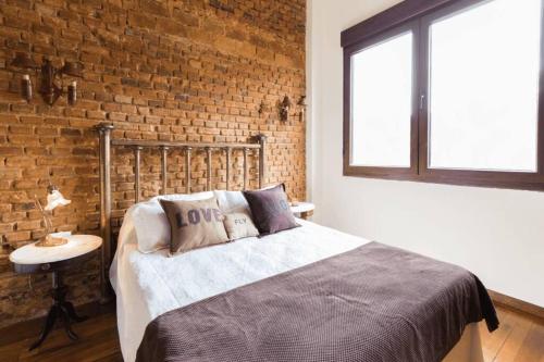 een slaapkamer met een bed en een bakstenen muur bij The Wall Montevideo [001] Live in The Old Town in Montevideo