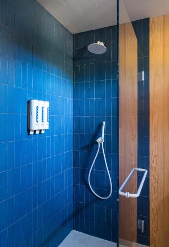 a blue tiled bathroom with a shower and a phone at The Sea Ranch Lodge in Sea Ranch