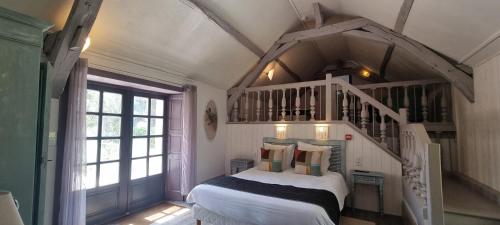 een slaapkamer met een wit bed en een trap bij Domaine de la Courbe Hôtel & Spa in Le Lude
