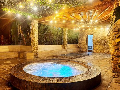 a large hot tub in a patio with lights at Hosteria Flor de Canela in Puyo