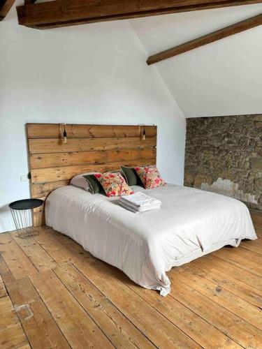 a bedroom with a large bed with a wooden headboard at Maison, appartement type Triplex atypique de charme à 5 minutes du port et des plages in Saint-Brieuc