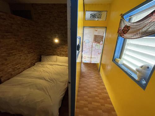 a small bedroom with a bed and a window at On My Way Dulan in Donghe