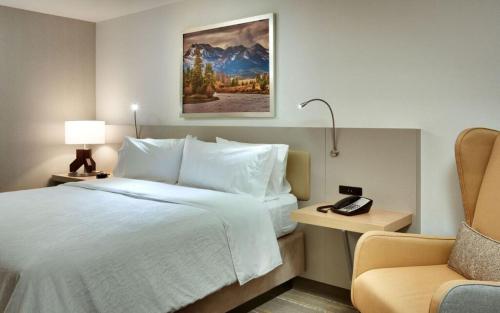 a hotel room with a large bed and a chair at Hilton Garden Inn Boise Downtown in Boise