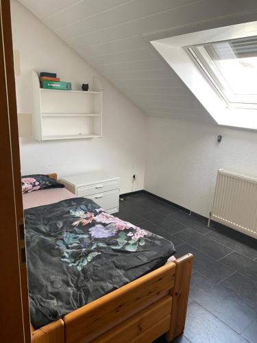 - une chambre avec un lit et une lucarne dans l'établissement Moderne Ferienwohnung Neckarschleife mit Klimaanlage, à Kirchheim am Neckar