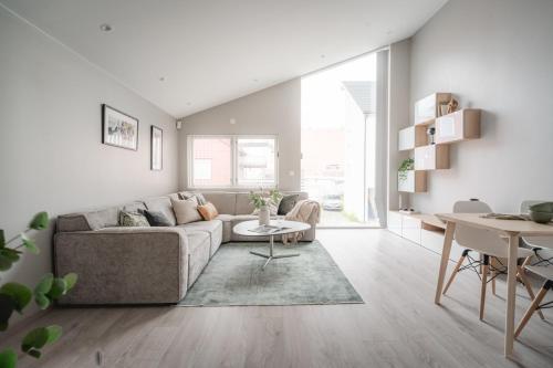 a living room with a couch and a table at Arctic Homes - Unique Town House in Tromsø