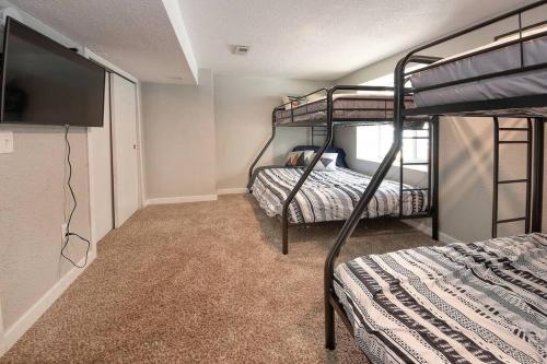 a bedroom with two bunk beds and a flat screen tv at Historic Home w/Pikes Peak Views in Colorado Springs