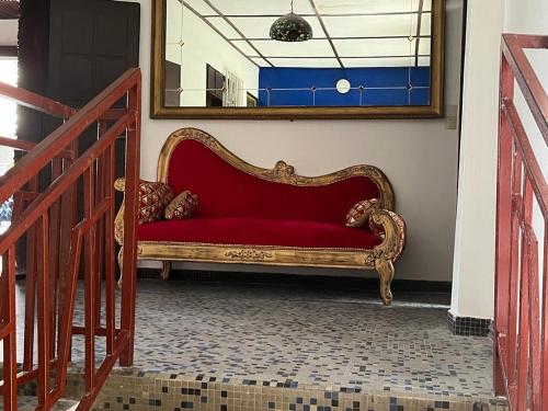 a red couch sitting in a room with a mirror at La Villa Saint Jean in Cotonou