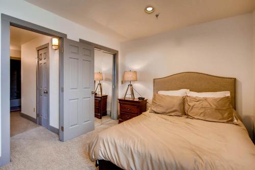 a bedroom with a bed and a door to a hallway at The Plaza Condominiums by Crested Butte Mountain Resort in Mount Crested Butte