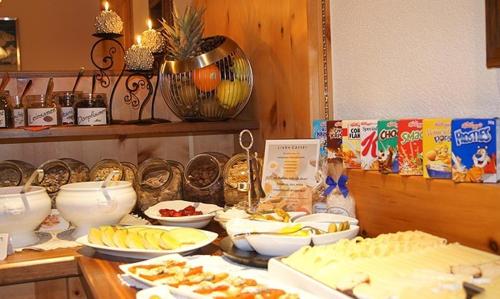 a counter with bowls and plates of food on it at Sport Garni Kapplerhof – Ischgl/Kappl in Kappl
