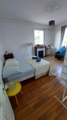 een slaapkamer met een groot bed en een gele kruk bij Bed & Breakfast à 20mn direct St Lazare en Train in Sannois