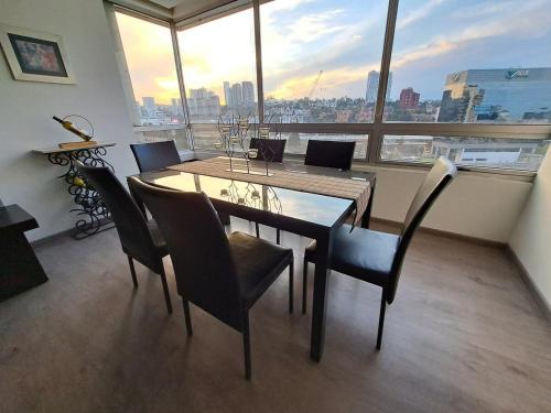 a dining room with a table and chairs and a large window at Maximum Glamor in the Park. La Mexicana and Expo Santa. Faith in Mexico City