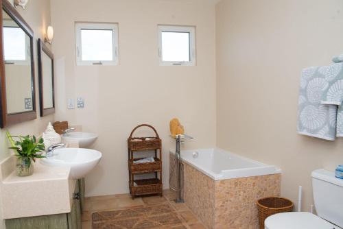a bathroom with a tub and a sink and a toilet at Marks Reef in Lance aux Épines