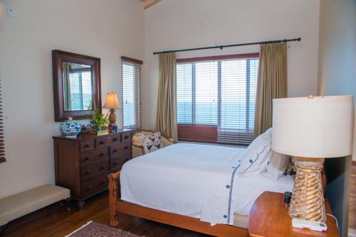 a bedroom with a bed and a table with a lamp at Marks Reef in Lance aux Épines
