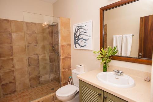 a bathroom with a toilet sink and a shower at Marks Reef in Lance aux Épines
