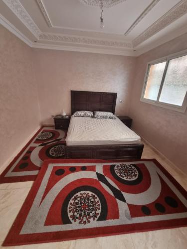 - une chambre avec un lit et deux tapis au sol dans l'établissement Appart tranquille au centre de marrakech, à Marrakech