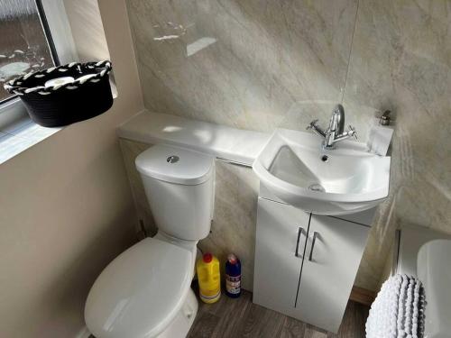 a bathroom with a white toilet and a sink at Spacious 2-Bedroom House In Stockton Heath With Free WiFi By Amazing Spaces Relocations Ltd in Warrington