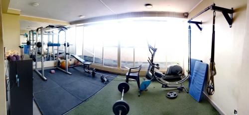 een fitnessruimte met diverse loopbanden en hometrainers bij Lindo Departamento Amoblado (Santiago) in Santiago