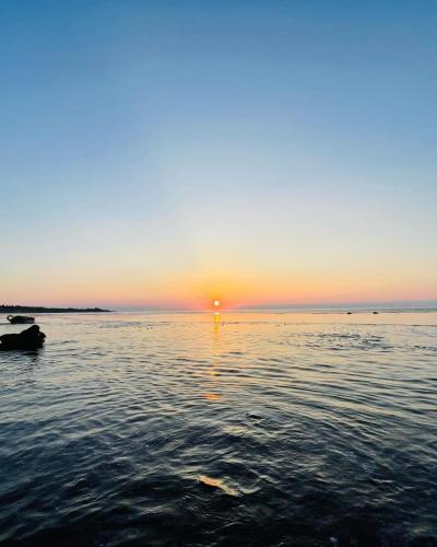 a sunset over a body of water with the sun setting at On My Way Dulan in Donghe