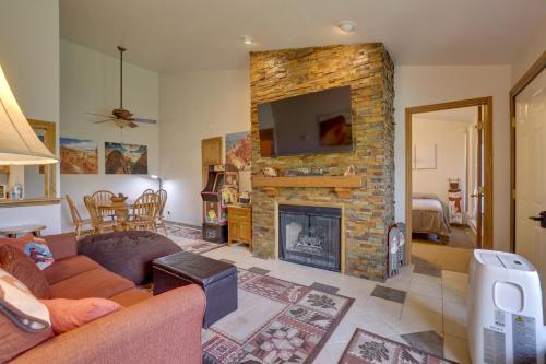a living room with a brick fireplace with a tv at Ski-InandSki-Out Brian Head Condo with Pool Access! in Brian Head