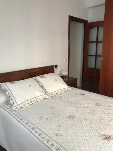 a bedroom with a large bed with a wooden headboard at Piso Cuatro Caminos in A Coruña