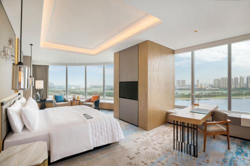 西安市にあるLe Méridien Xi'an Chanbaの大きなベッドとデスクが備わるホテルルームです。