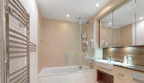 倫敦的住宿－Ontario Point Flat only double bedroom，带浴缸、水槽和淋浴的浴室