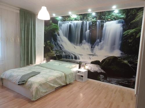 a bedroom with a waterfall mural on the wall at Great location In Helsinki in Helsinki