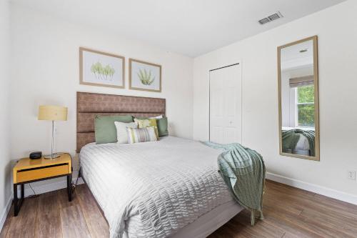 um quarto branco com uma cama, uma mesa e um espelho em Hot Tub included 4 BR at Regal Oaks RO2761N em Kissimmee