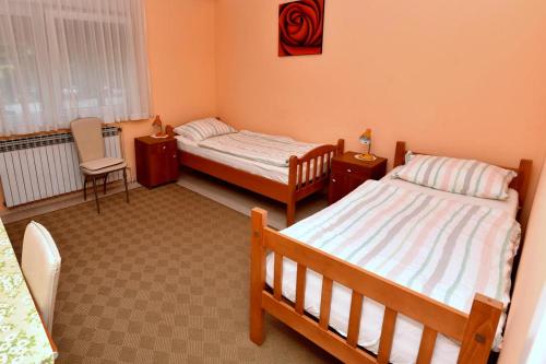 a bedroom with two beds and a chair in it at Štefanija Apartmani in Nedelišće
