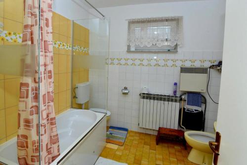 a bathroom with a tub and a toilet at Štefanija Apartmani in Nedelišće
