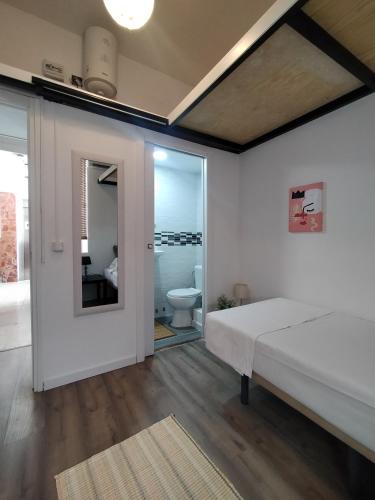 a bedroom with a bed and a bathroom with a toilet at Alanta Apartments in Madrid