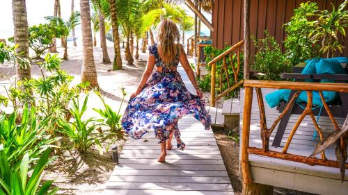 a woman in a dress walking down a porch at Azure Del Mar in Maya Beach