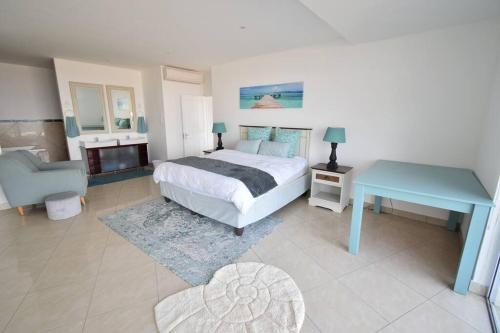 a bedroom with a bed and a table and a chair at Seaside Getaway in Margate