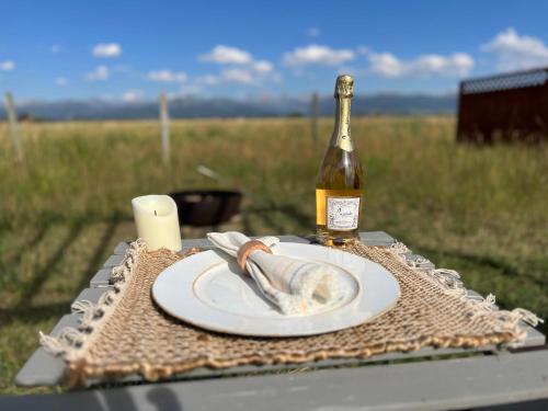 - une bouteille de vin et une assiette de nourriture sur une table dans l'établissement Teton View Studio - Hidden Gem near Yellowstone, à Tetonia