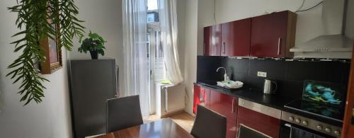 una cocina con armarios rojos y una mesa con una planta en ELENA flat Orchidee Duisburg Zentrum, en Duisburg