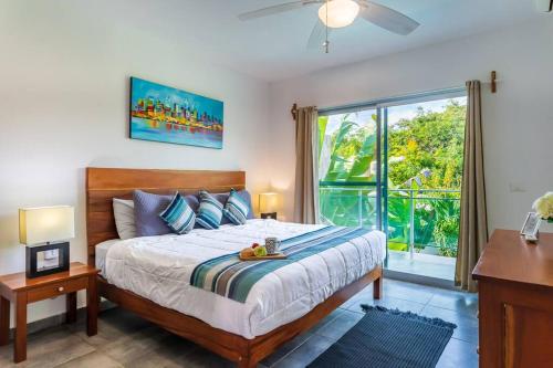 une chambre avec un lit et une grande fenêtre dans l'établissement Casa Alegria BY Sandy Powerful, à Tulum