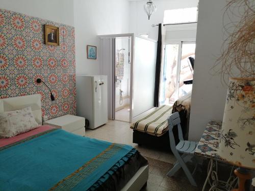 a bedroom with a bed and a table and a window at The 18, Marsa Guest House in La Marsa