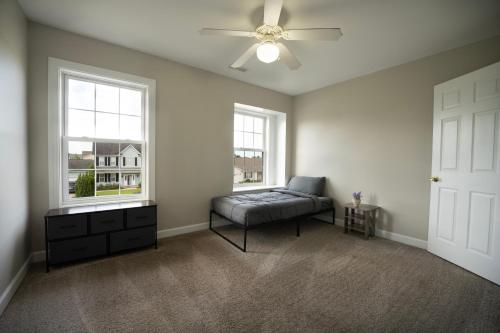 an empty living room with a couch and two windows at Beautiful home near Marine Corps base in Jacksonville