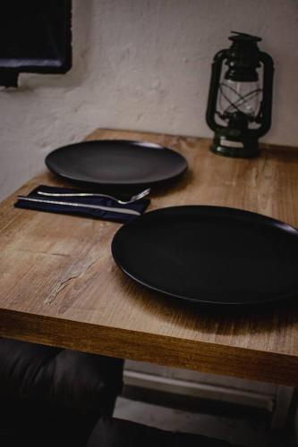 two black plates sitting on top of a wooden table at Vojenský bunker in Bratislava