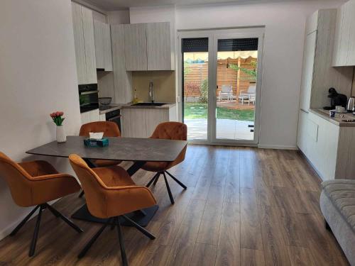 eine Küche und ein Wohnzimmer mit einem Tisch und Stühlen in der Unterkunft Sika Sunny Garden Apartment in Arad