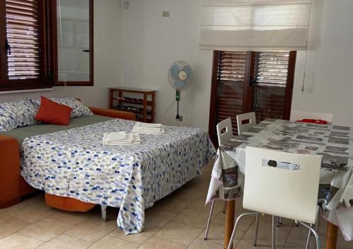 una camera con letto, tavolo e sedie di Magellano Apartments a Pontecagnano