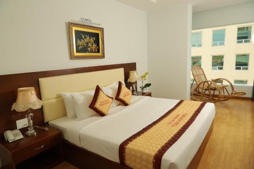 a bedroom with a bed and a table and a chair at Pleiku & Em Hotel by Gia Lai Tourist in Pleiku