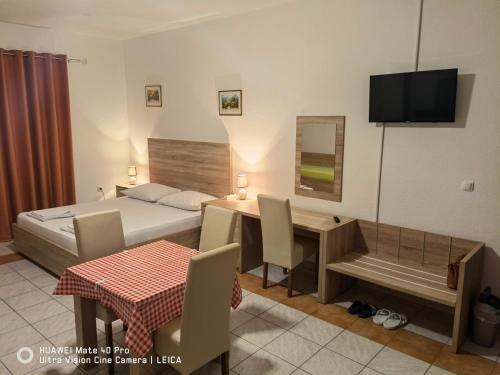 a bedroom with a bed and a table and a desk at Lovely Home City Center in Mostar