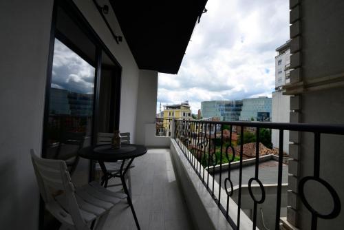 a balcony with a table and chairs and a view of a city at Tirana Central Apartments - Premium in Tirana
