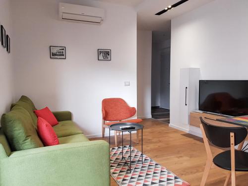 uma sala de estar com um sofá e cadeiras e uma televisão em Tirana Central Apartments - Premium em Tirana