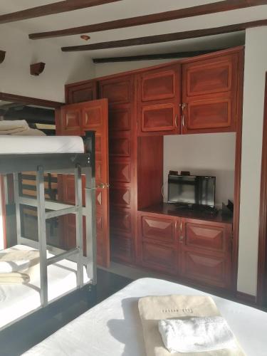 a room with wooden cabinets and a bed and a microwave at Hotel Boutique Babilonia Manizales in Manizales