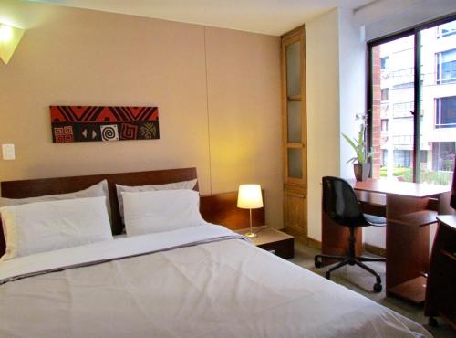 1 dormitorio con cama, escritorio y silla en PLAZA de NAVARRA, en Bogotá