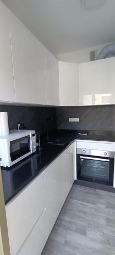 une cuisine avec des armoires blanches et un micro-ondes dans l'établissement Casa Bella Vita, à Menton