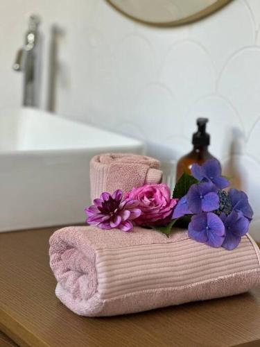 - une serviette rose avec des fleurs violettes sur un comptoir de salle de bains dans l'établissement 